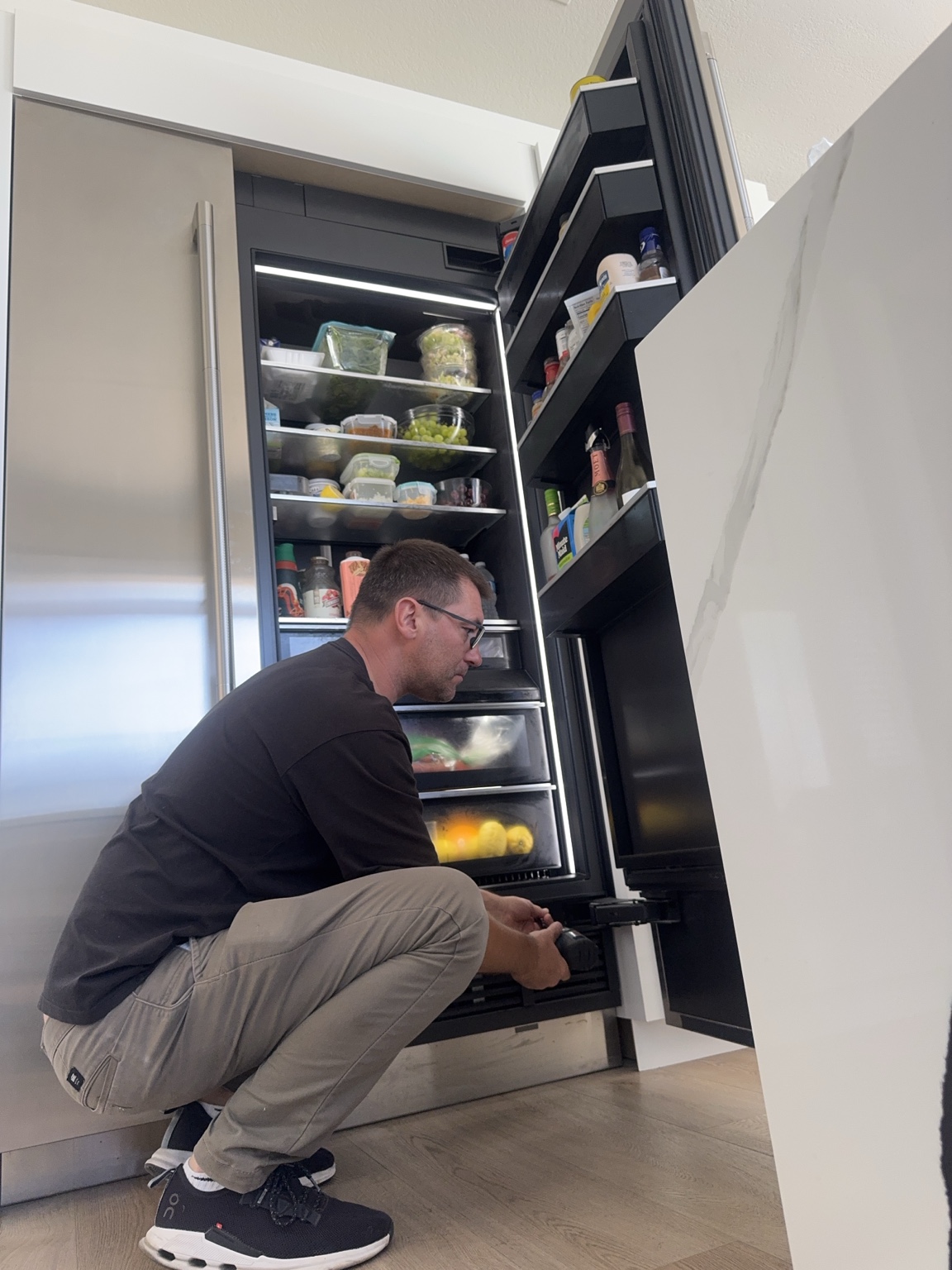 Technician repairing built-in refrigerator